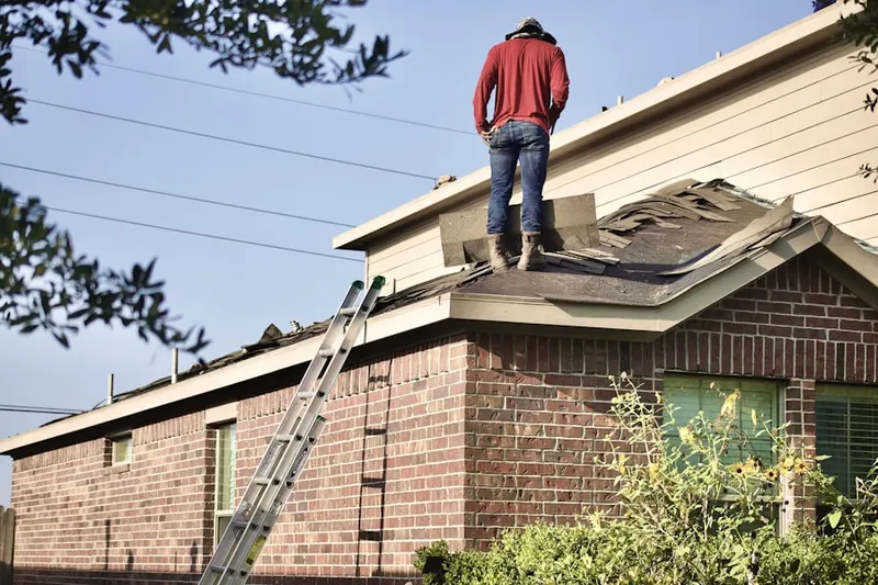 Professional roofer working on a residential roof in Ledyard Center